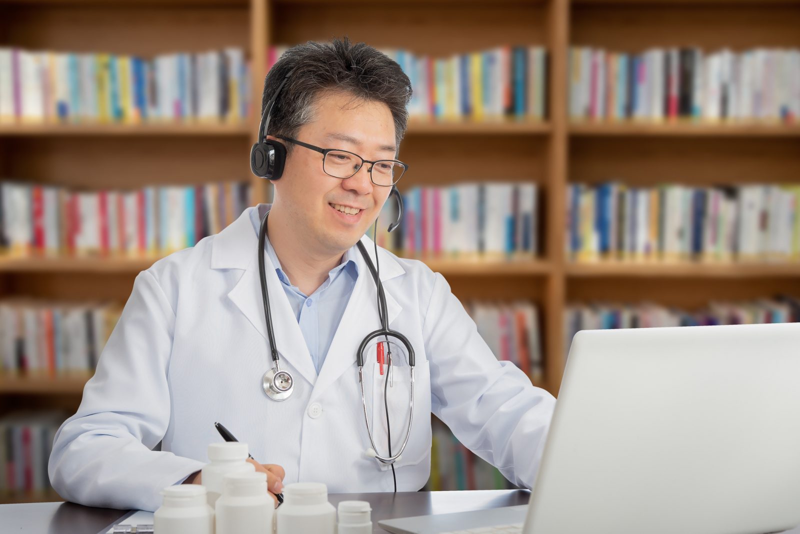 an Asian doctor who is remotely consulting with a patient. Telehealth concept.